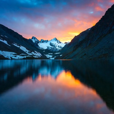 Sunset over snowy mountain lake