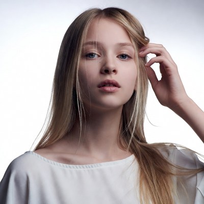 Blonde girl touching hair thoughtfully