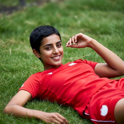 Smiling Asian woman lying on grass