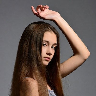Teen girl raising hand over head