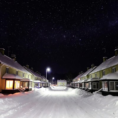 Snowy Street with Houses Under Starry Night Sky