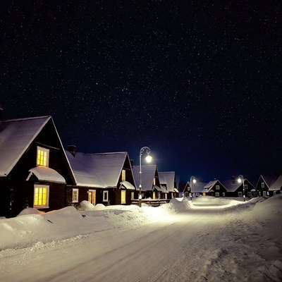 Snowy Wooden Cottages Under Starry Night Sky