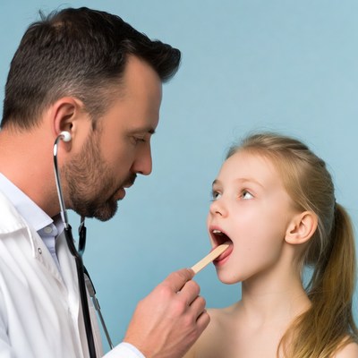 Doctor examining girl's throat