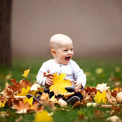 Baby holding yellow fall leaf