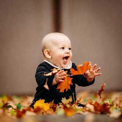 Baby holding autumn leaves