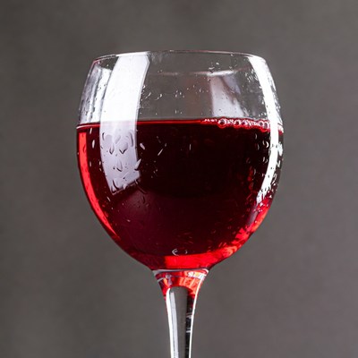 Red wine glass with water droplets