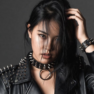 Asian woman in spiked leather jacket