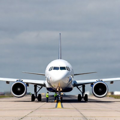 White Airplane Parked on Tarmac with Ground Crew