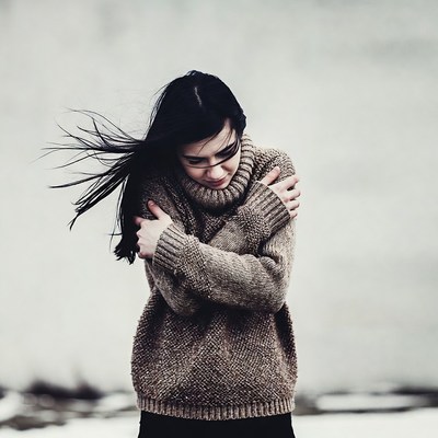 Woman hugging herself in sweater