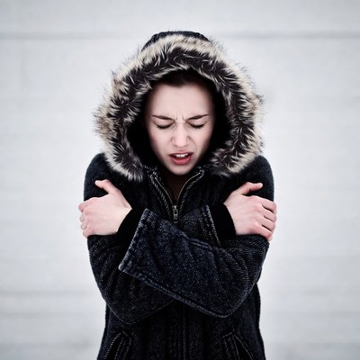 Woman shivering in fur hood jacket