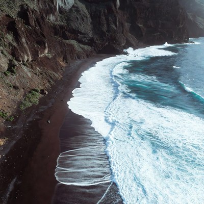 Black Sand Beach with Cliffs and Waves