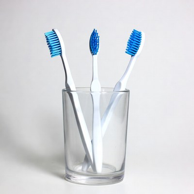 Three Blue Toothbrushes in Glass