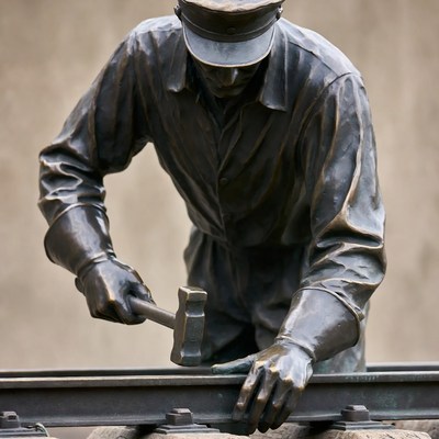 Bronze statue of worker hammering railroad track