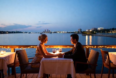 Couple holding hands at dockside dinner