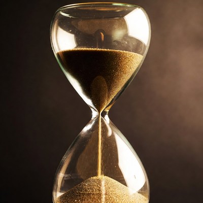 Sand flowing in glass hourglass