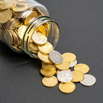Glass Jar Pouring Gold and Silver Coins