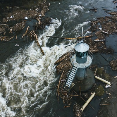 Lighthouse amid river debris flood