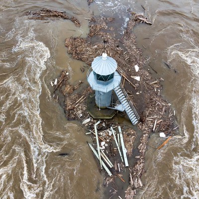 Lighthouse surrounded by flood debris
