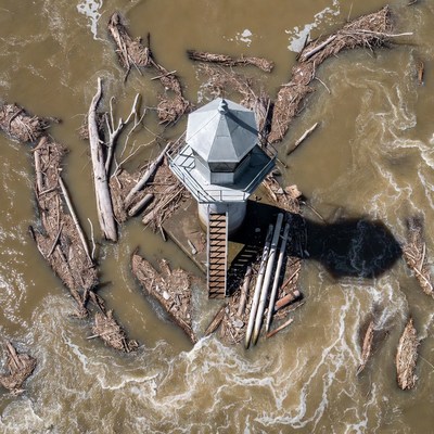 Lighthouse surrounded by flood debris