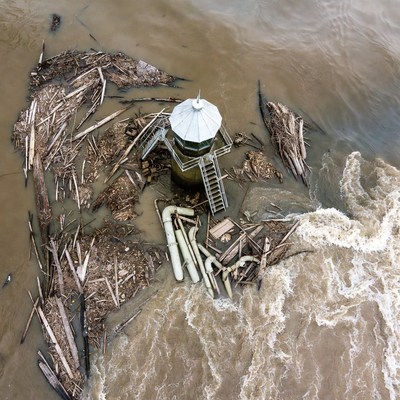 Lighthouse surrounded by flood debris