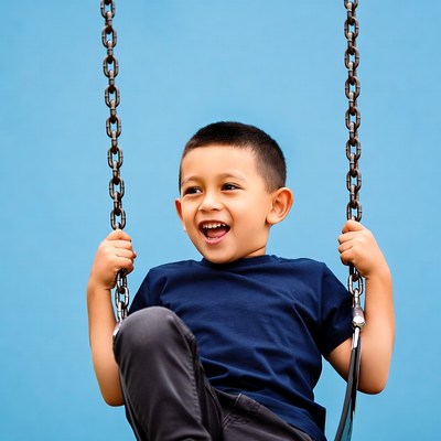 Boy smiling on playground swing
