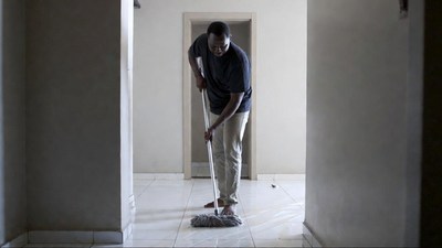 African man mopping floor