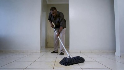 African man mopping floor