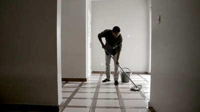 Man mopping floor in hallway