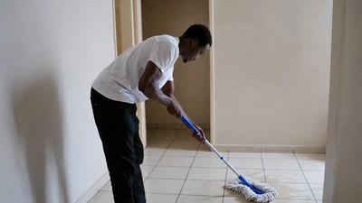 African-American man mopping floor