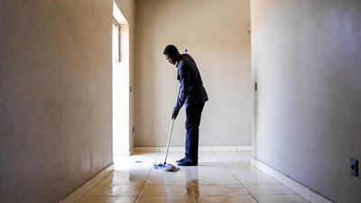 African man mopping wet floor