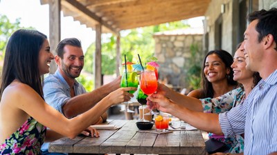 Group toasting colorful cocktails on patio