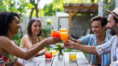 Friends cheering with cocktails outdoors