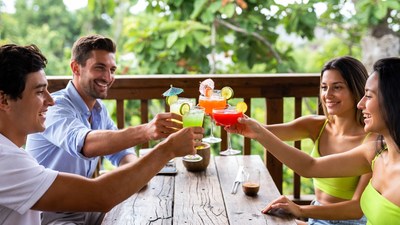 Friends cheering with cocktails on balcony