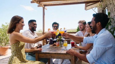 Diverse group toasting drinks on terrace