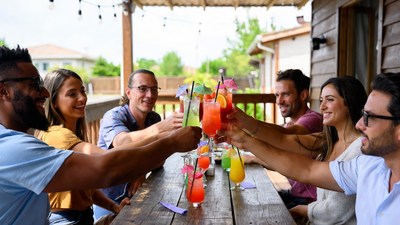 Diverse group toasting cocktails on porch