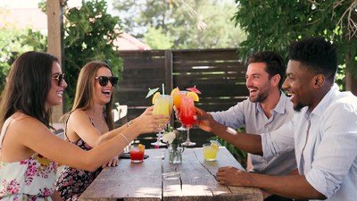 Friends toasting colorful cocktails outdoors