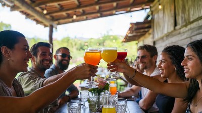 Group toasting with orange cocktails outdoors