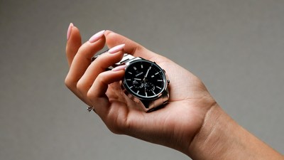 Woman's hand holding silver watch