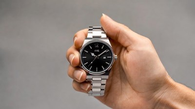 Man's hand holding silver watch