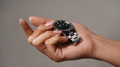 Woman holding black metal watch