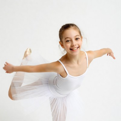 Young girl in white tutu doing ballet pose