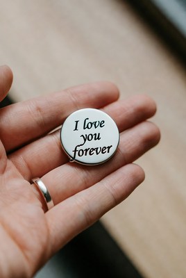 Hand holding 'I Love You Forever' button