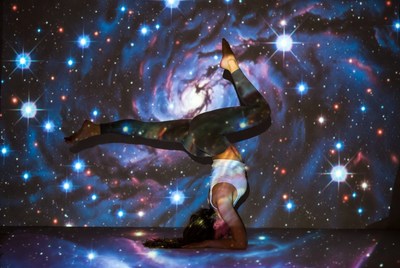 Woman in headstand yoga pose with galaxy
