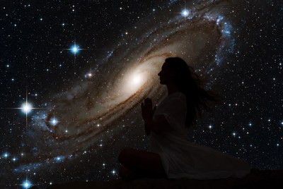 Woman praying silhouette with galaxy