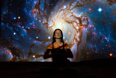 Woman meditating in cosmic galaxy