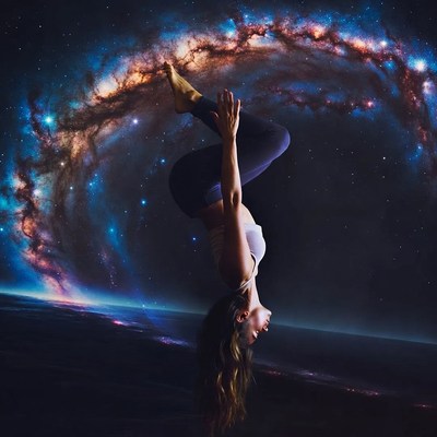 Woman in yoga headstand amid galaxy