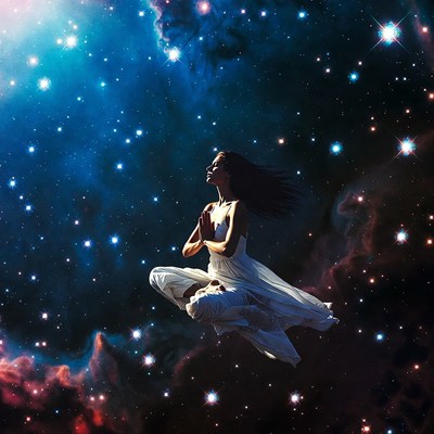 Woman meditating in starry nebula