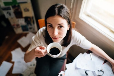 Woman holding coffee mug at desk