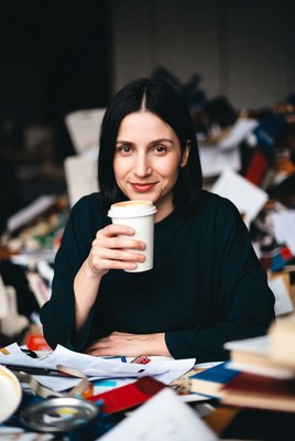 Woman holding coffee cup amid papers