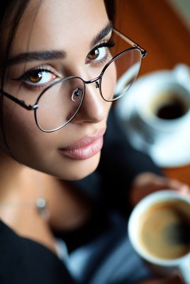 Woman holding coffee cup with glasses